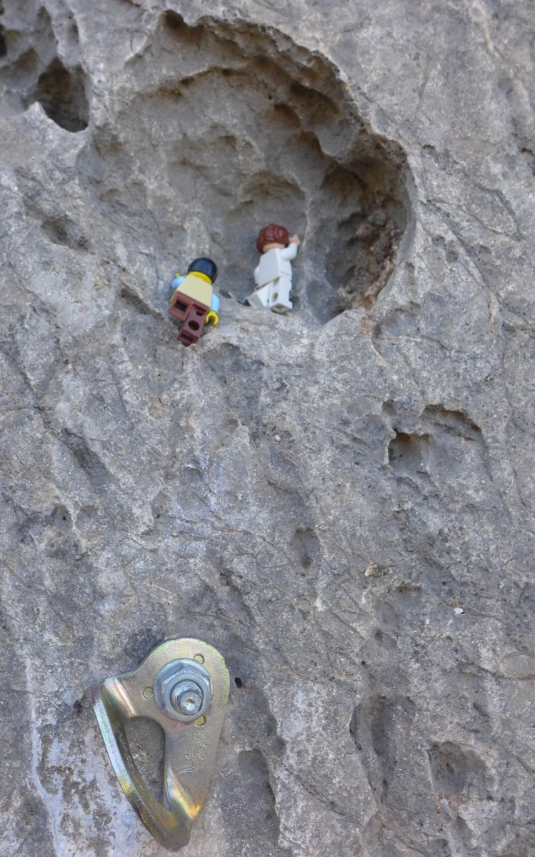 Lego figures climbing up some rock